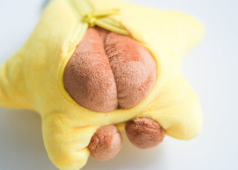 Yellow plush toy shaped like a star with a brown center on a white background