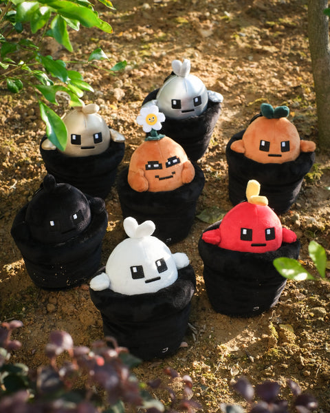 Set of Potatoz plush toys resembling characters from a video game, standing on a natural ground background.