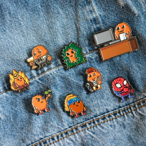 Set of colorful Potatoz pins on a denim background